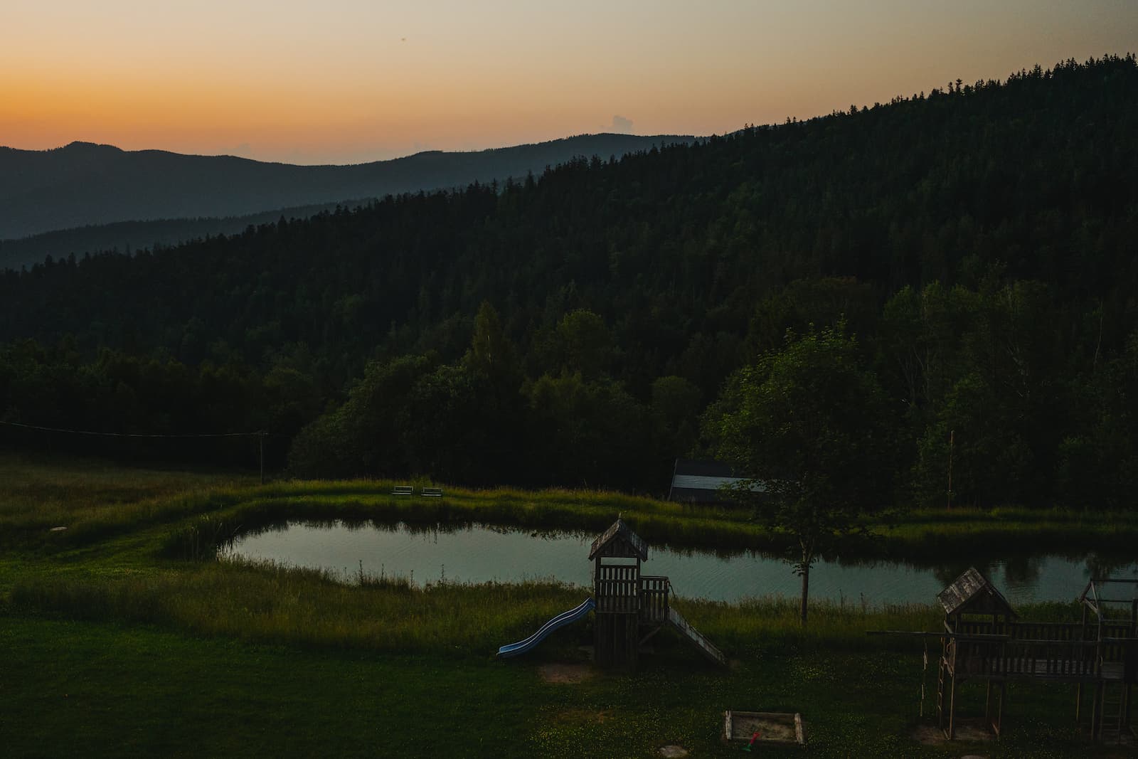 Romantische Hochzeitsfotografie im Abendlicht in Lohberg mit Blick auf einen idyllischen Teich und Spielplatz.
