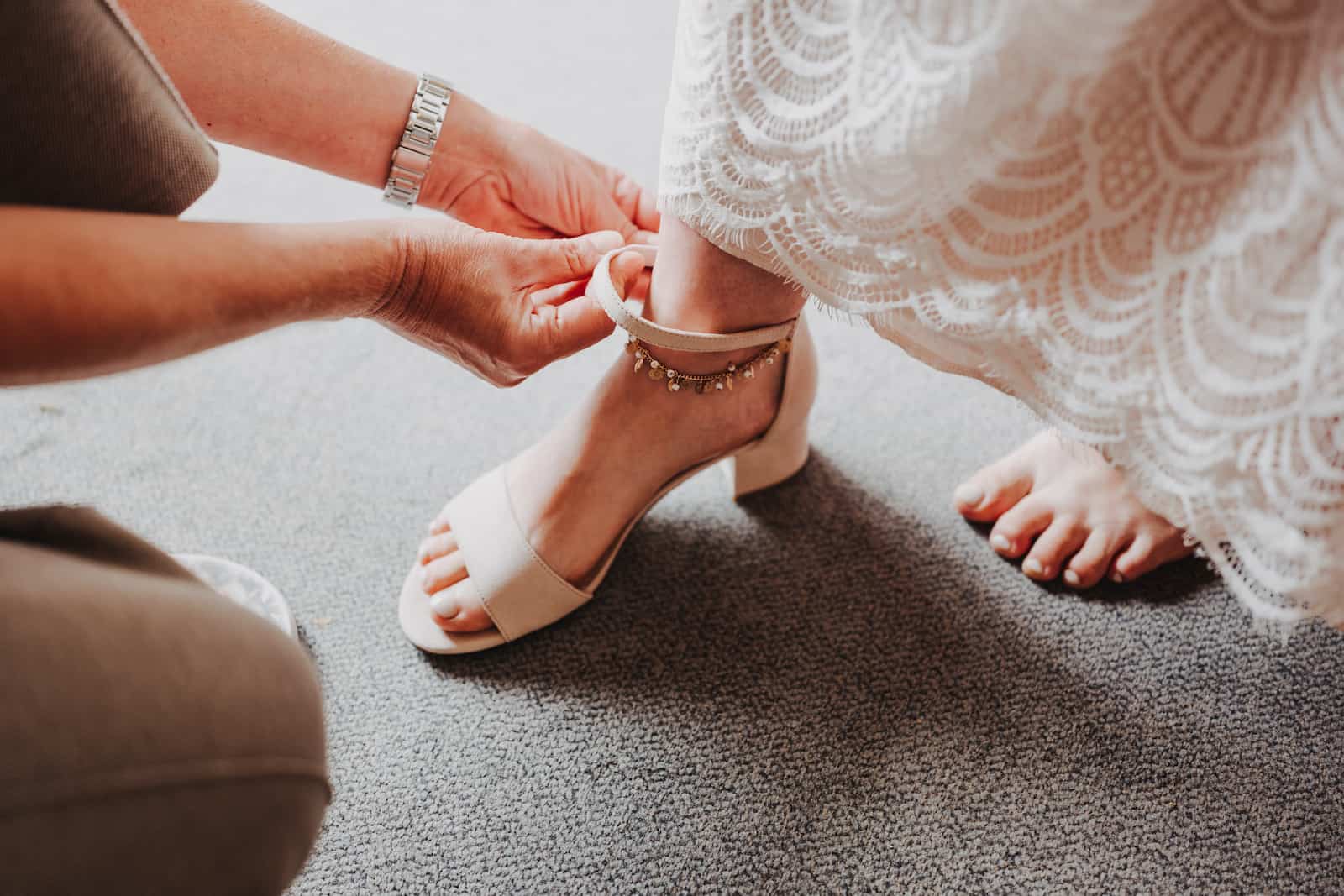 Detailaufnahme einer Braut, die ihre Schuhe für die standesamtliche Hochzeit anzieht, fotografiert von Niklas Hesser in Lohberg.
