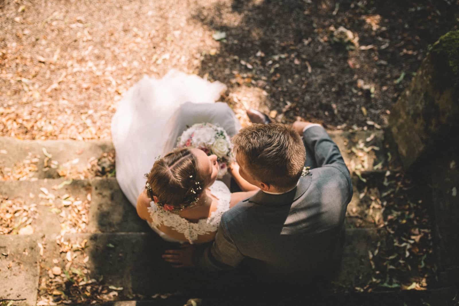 Hochzeitsfotografie in Möckmühl: Brautpaar auf einer Treppe, aufgenommen vom Hochzeitsfotografen Niklas Hesser.