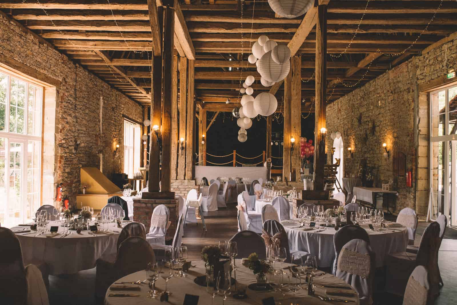 Elegante Hochzeitsdekoration in einer rustikalen Scheune in Möckmühl, fotografiert vom Hochzeitsfotografen Niklas Hesser.