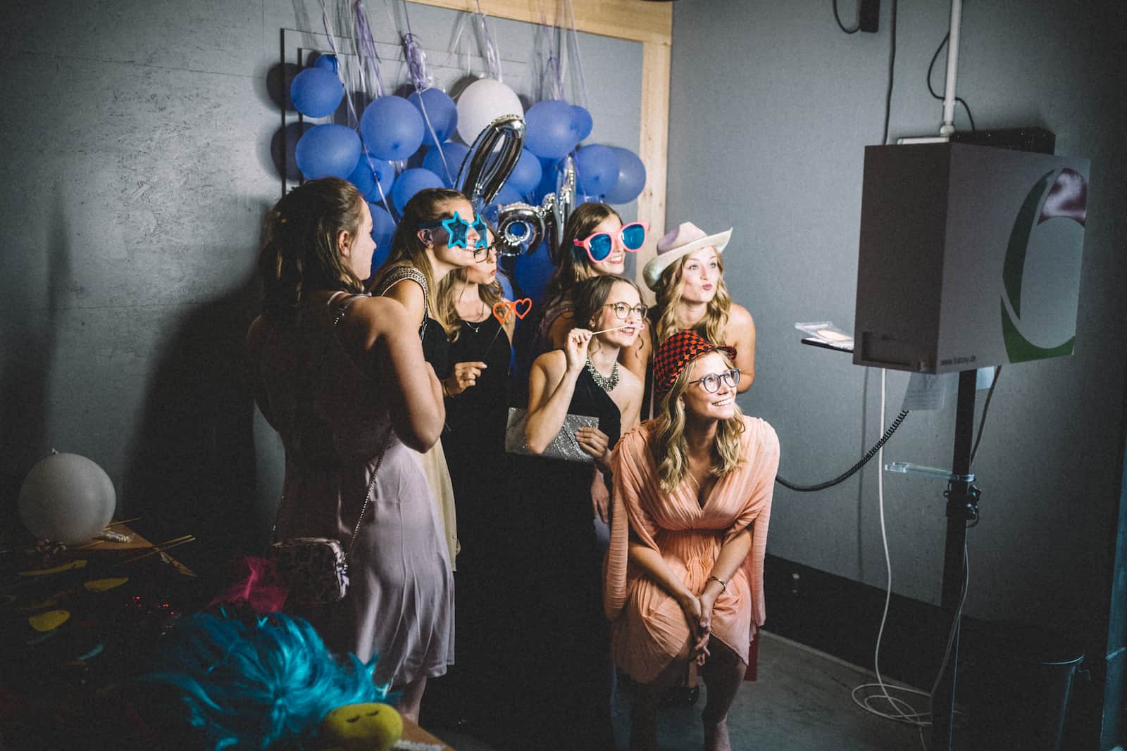Fröhliche Hochzeitsgäste posieren in einer Fotobox bei einer Hochzeit in Wüstenrot, aufgenommen vom Hochzeitsfotografen Niklas Hesser.