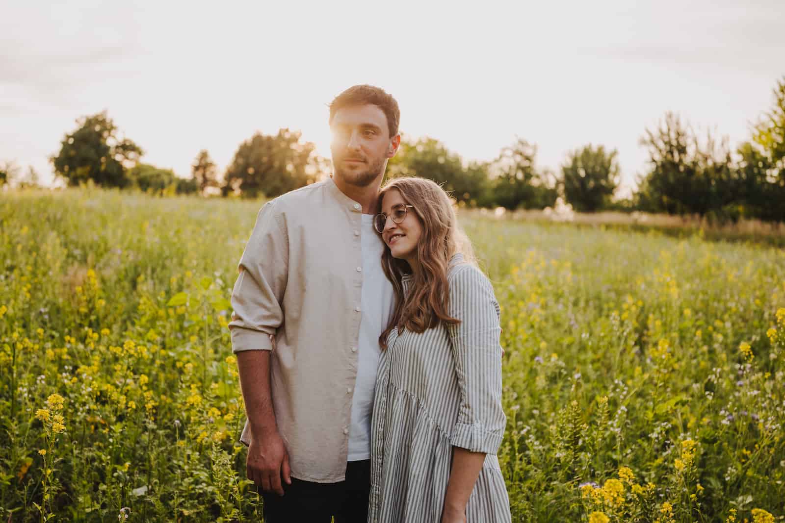 Paar beim Fotoshooting in Neckarsulm auf einer Blumenwiese bei Sonnenuntergang, fotografiert vom Eventfotografen Niklas Hesser.