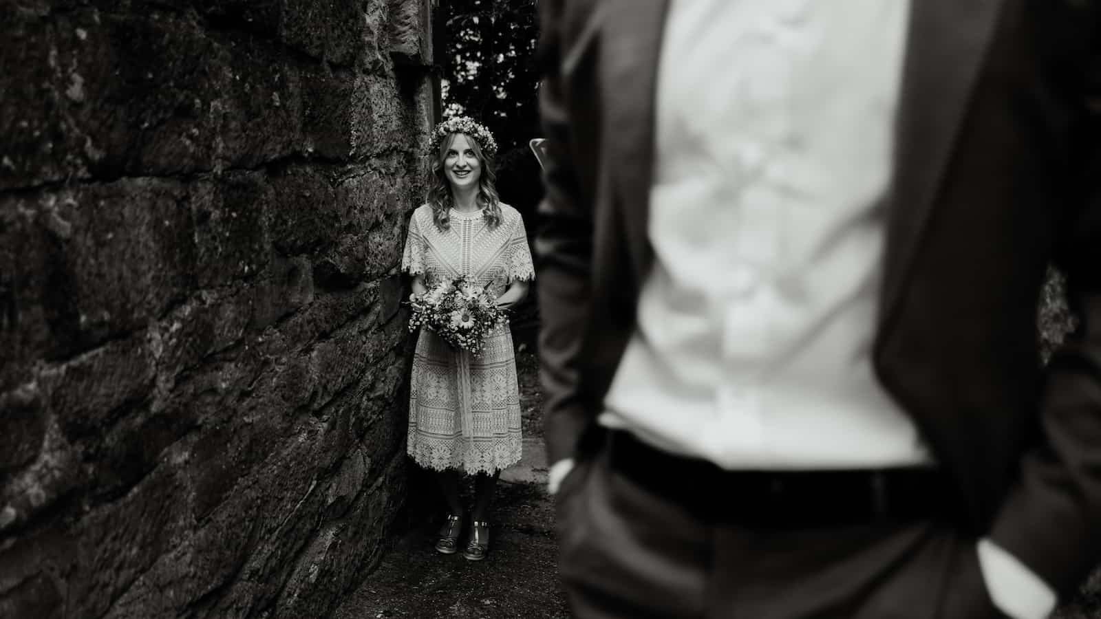 Standesamt Fotografie in Lauffen am Neckar, Braut lächelt hinter Bräutigam in einem schmalen Gang.