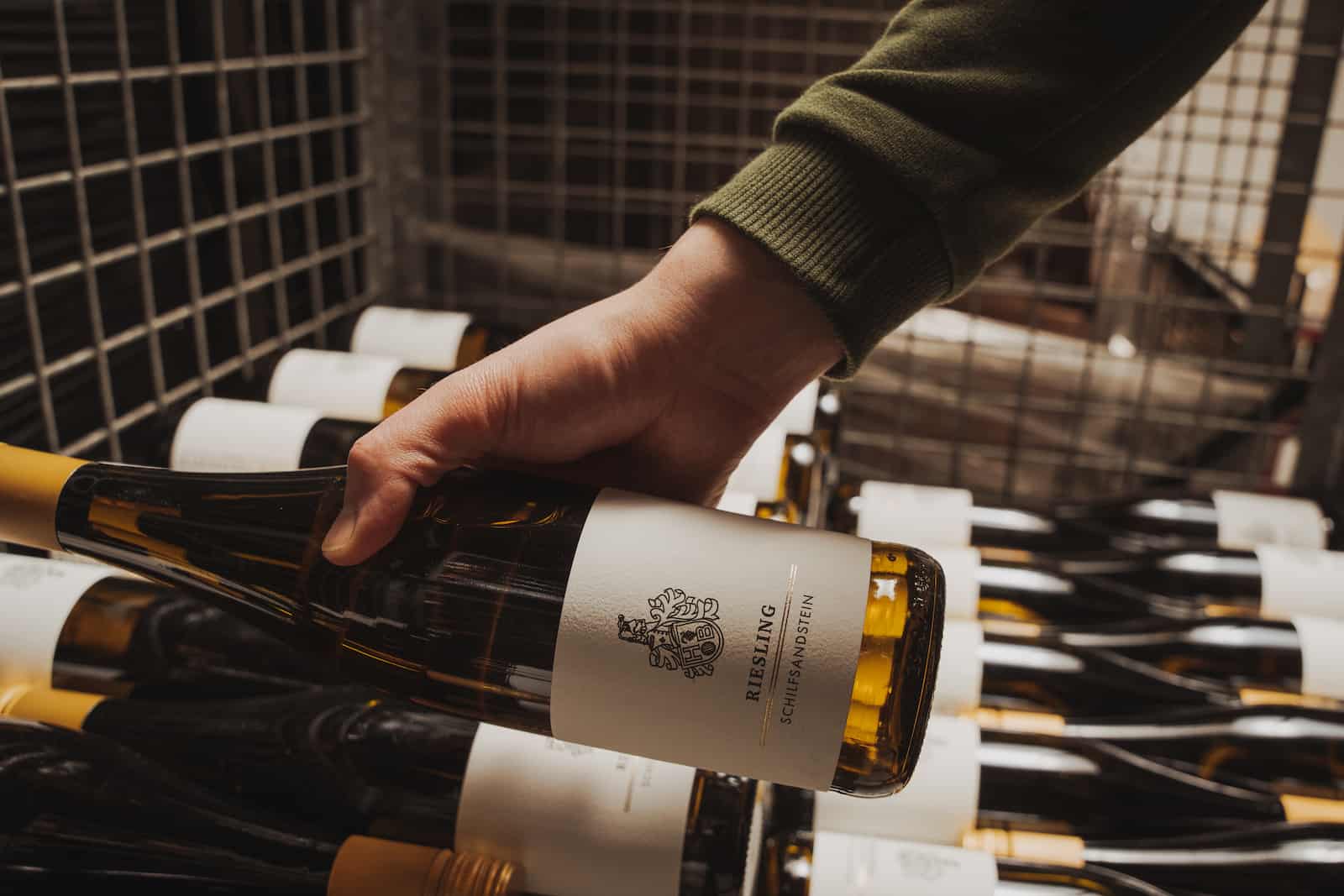 Unternehmensreportage in Erlenbach: Hand hält Weinflasche im Lager