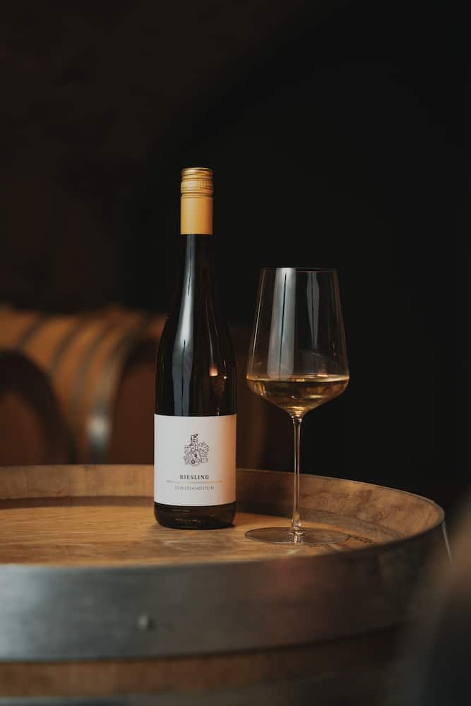 Weinflasche und Glas auf einem Weinfass in Erlenbach, fotografiert vom Eventfotografen Niklas Hesser