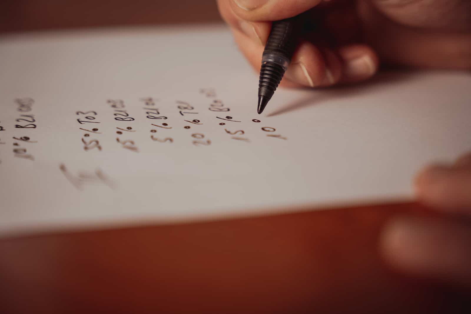 Detailaufnahme einer Hand, die Notizen auf Papier schreibt, Unternehmensreportage in Erlenbach