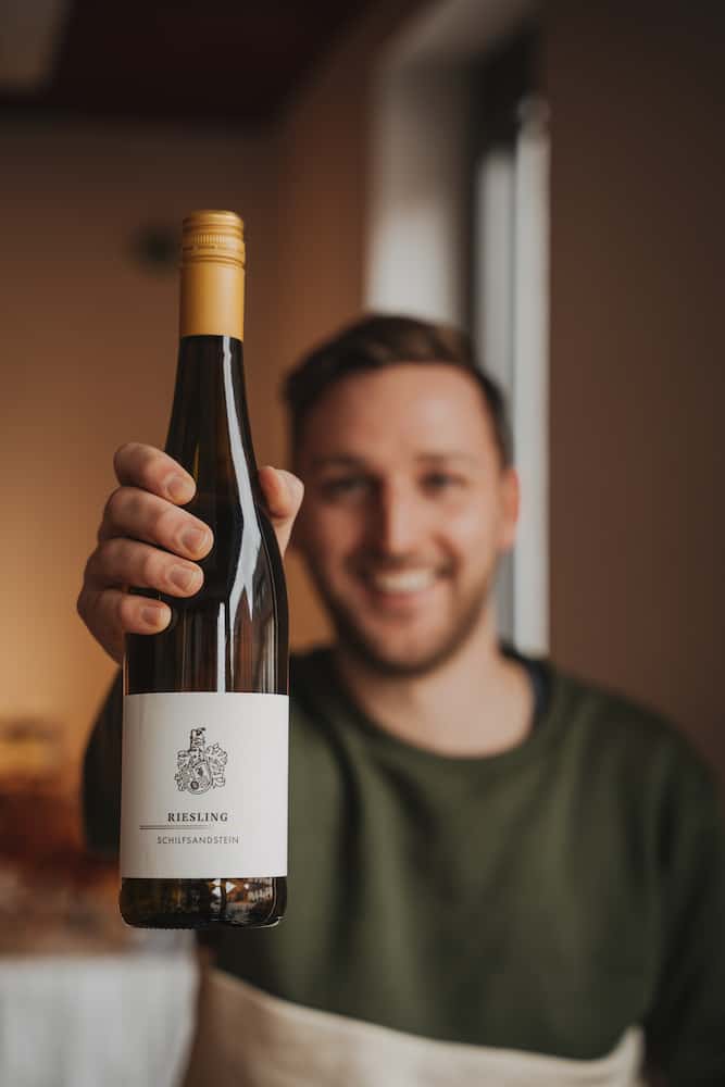Mann hält eine Flasche Riesling in einem Unternehmensreportage-Shooting in Erlenbach.