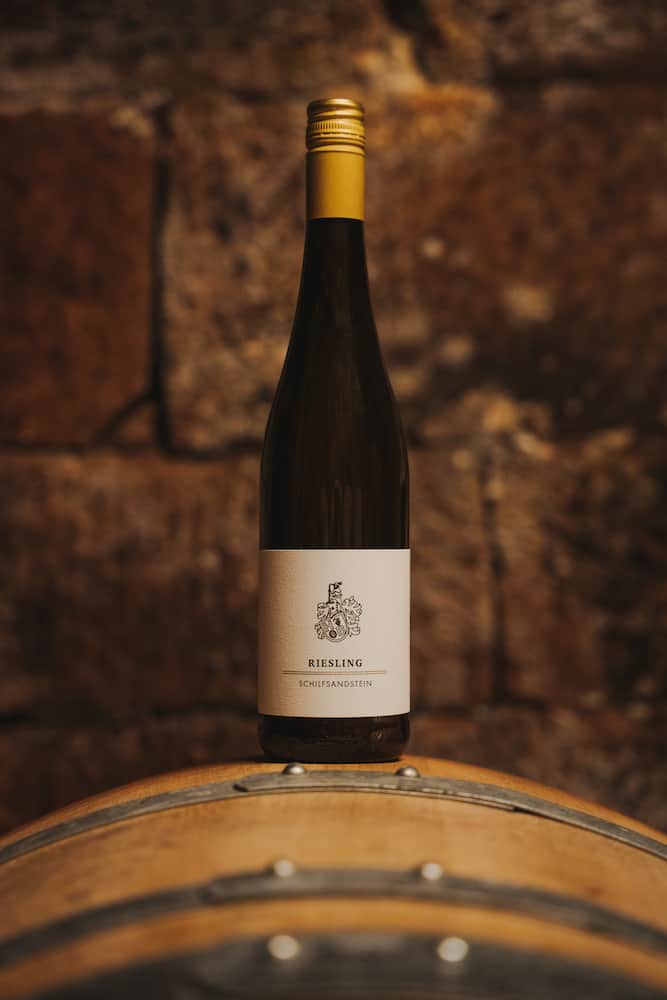 Professionelle Eventfotografie in Erlenbach: Eine stilvolle Flasche Riesling auf einem Weinfass, aufgenommen vom Eventfotografen Niklas Hesser.