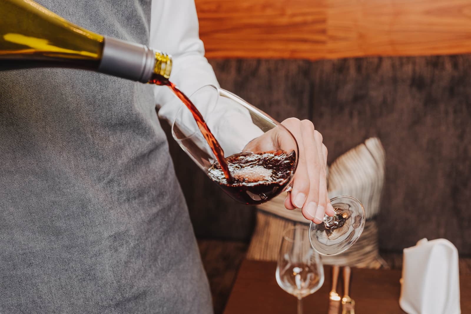 Businessfotografie in Heilbronn: Ein Kellner schenkt Wein in ein Glas ein.