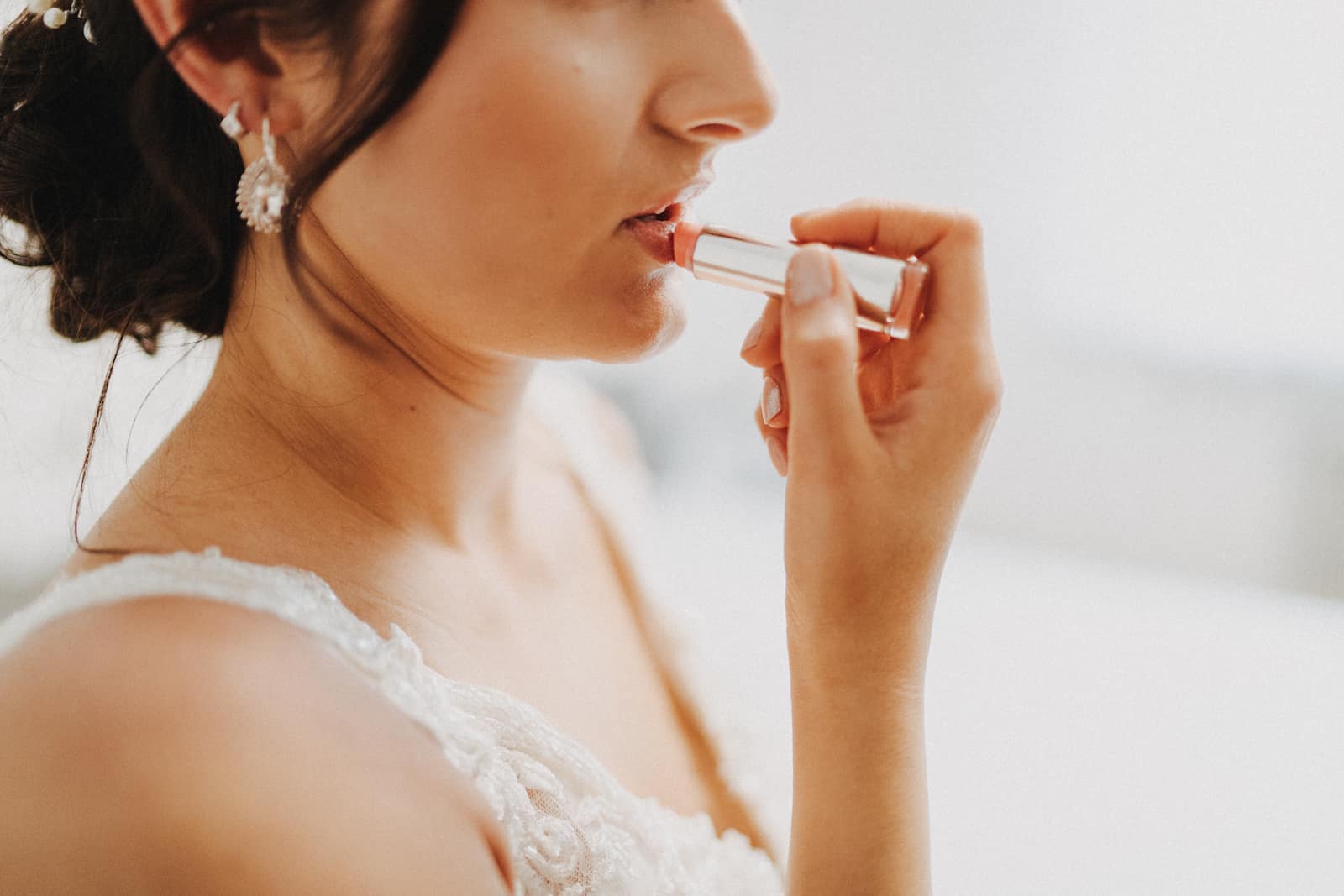Braut trägt Lippenstift auf vor der Hochzeit in Backnang, festgehalten von einem Hochzeitsfotografen.