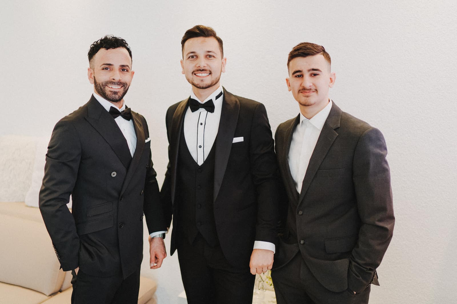 Drei Männer in eleganten Anzügen bei einer Hochzeitsfeier in Backnang, fotografiert vom Hochzeitsfotografen Niklas Hesser.