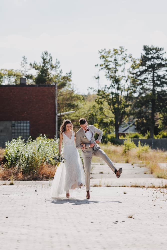 Hochzeitsfotografie Heilbronn: Brautpaar Maike und Patrick bei einem fröhlichen Spaziergang im Freien, aufgenommen vom Hochzeitsfotografen Niklas Hesser.