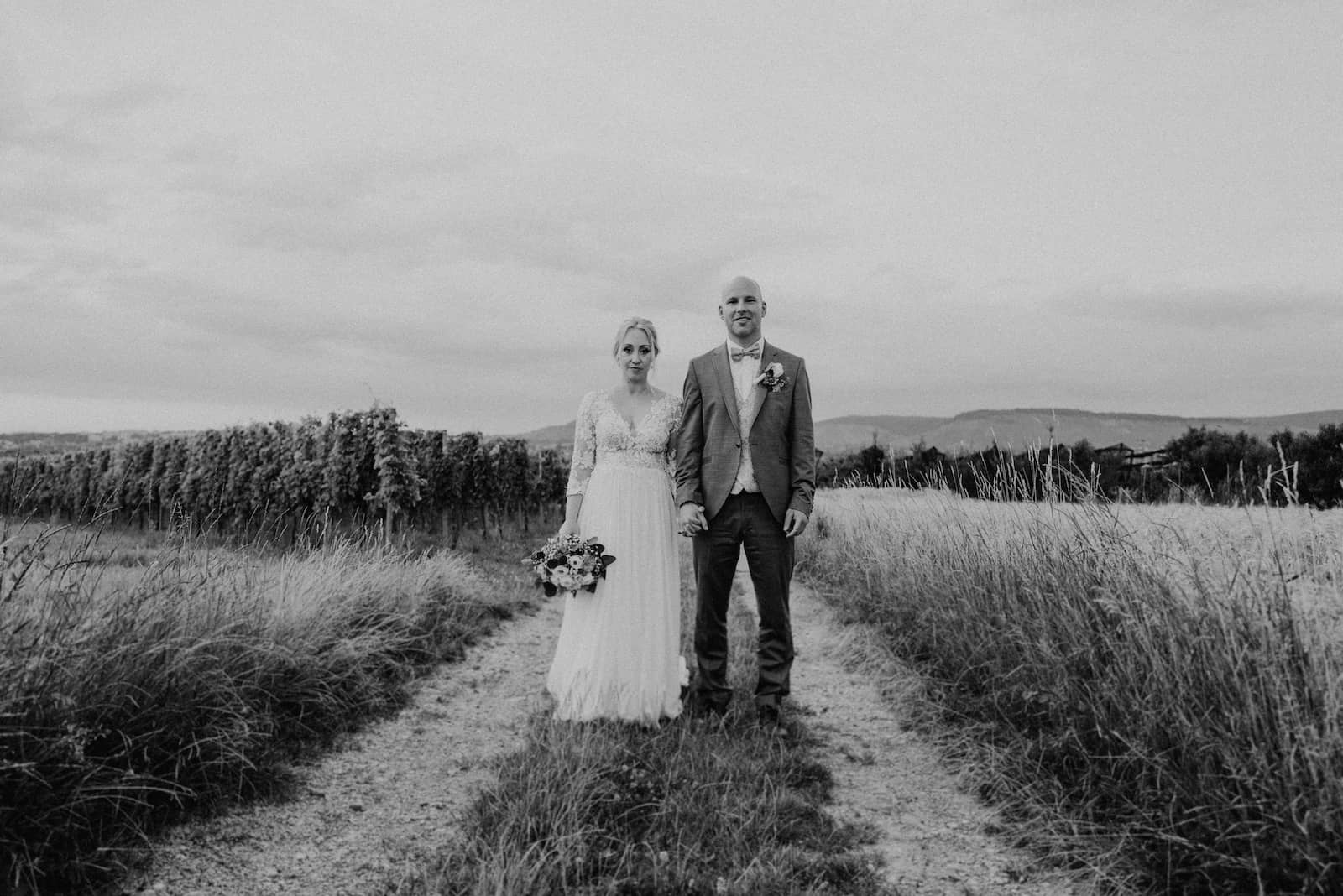 Hochzeitsfotografie in Kernen mit einem Brautpaar auf einem Feldweg, aufgenommen vom Hochzeitsfotografen Niklas Hesser.