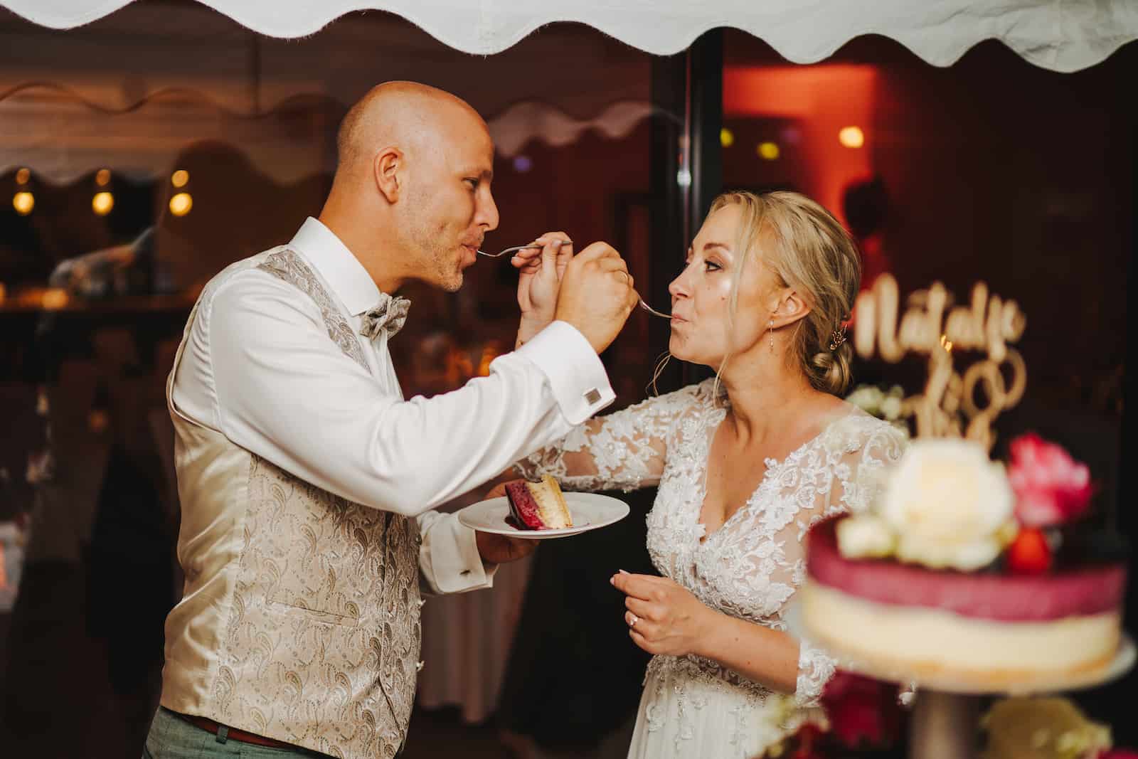 Hochzeitsfotografie in Kernen: Brautpaar beim Tortenanschnitt, festgehalten vom Hochzeitsfotografen Niklas Hesser.