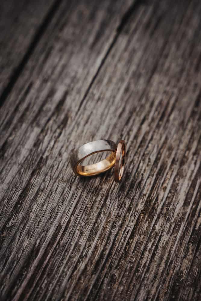 Hochzeitsringe auf Holzoberfläche, fotografiert vom Hochzeitsfotografen Niklas Hesser in Kernen