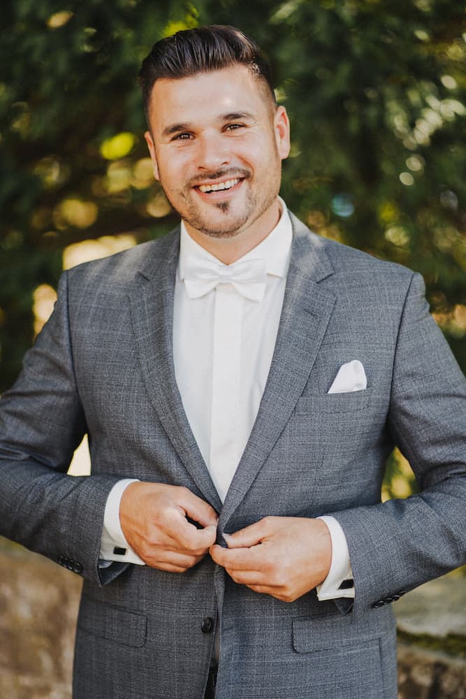 Standesamt Fotografie in Neckarsulm: Bräutigam im grauen Anzug lächelt bei natürlichem Licht