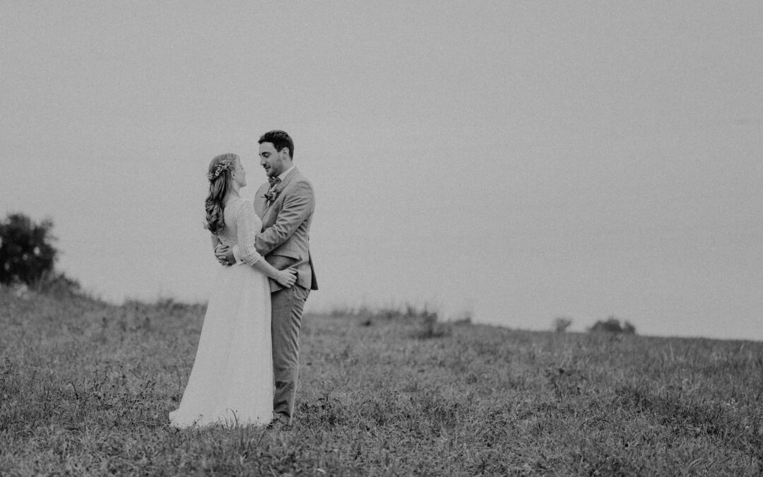 Hochzeitsreportage in Langenbeutingen, aufgenommen vom Hochzeitsfotografen Niklas Hesser, zeigt ein Brautpaar in inniger Umarmung auf einer Wiese.