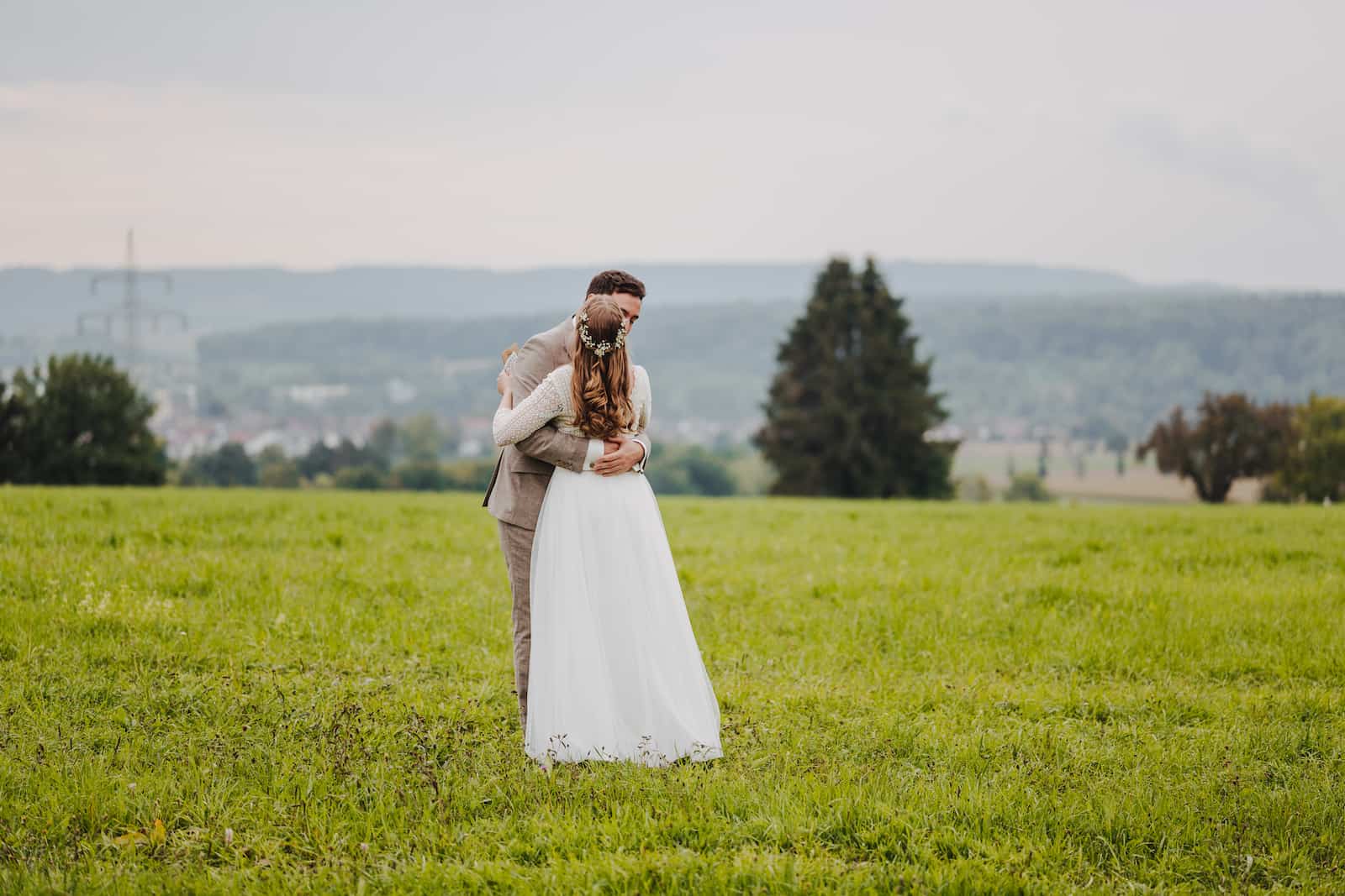 Hochzeitsfotografie in Langenbeutingen: Brautpaar umarmt sich auf einer grünen Wiese
