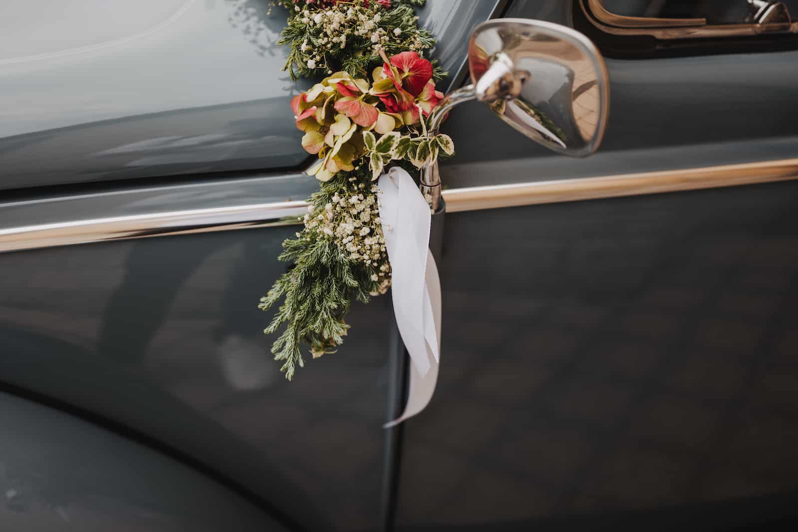Detailaufnahme eines Hochzeitsautos mit Blumenschmuck, fotografiert bei einer Hochzeitsreportage in Langenbeutingen.