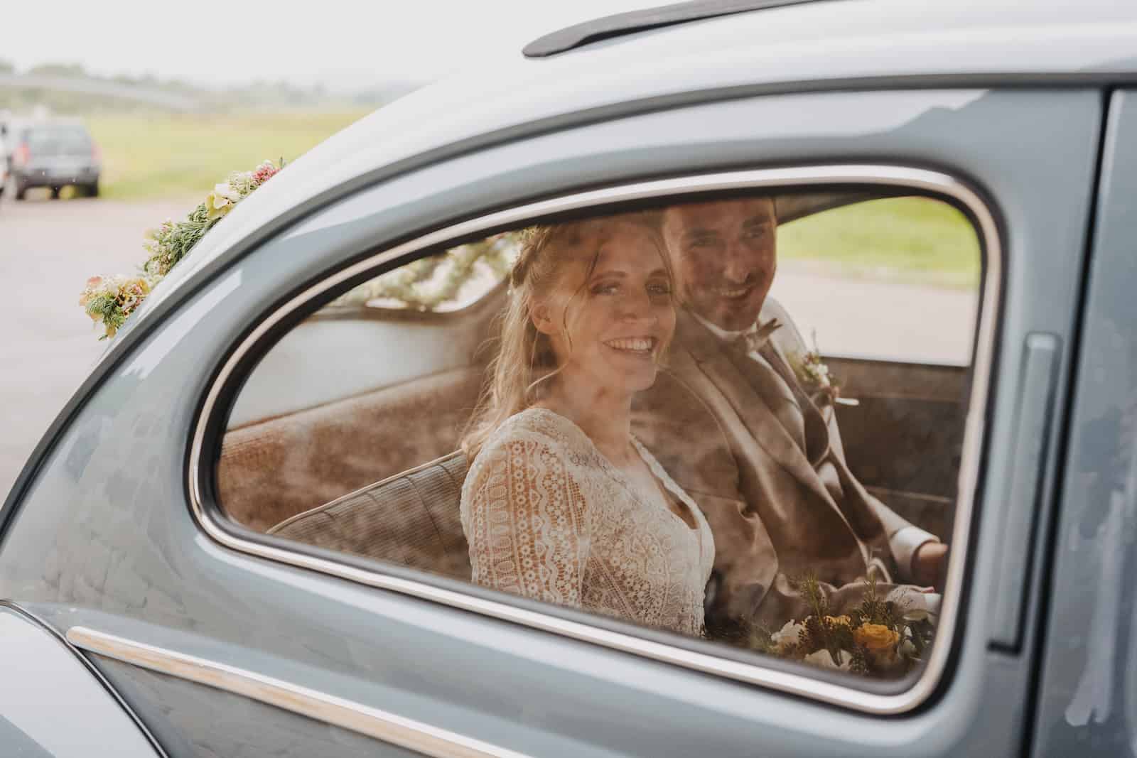 Hochzeitsreportage in Langenbeutingen mit einem glücklichen Brautpaar im Auto, fotografiert vom Hochzeitsfotografen Niklas Hesser.