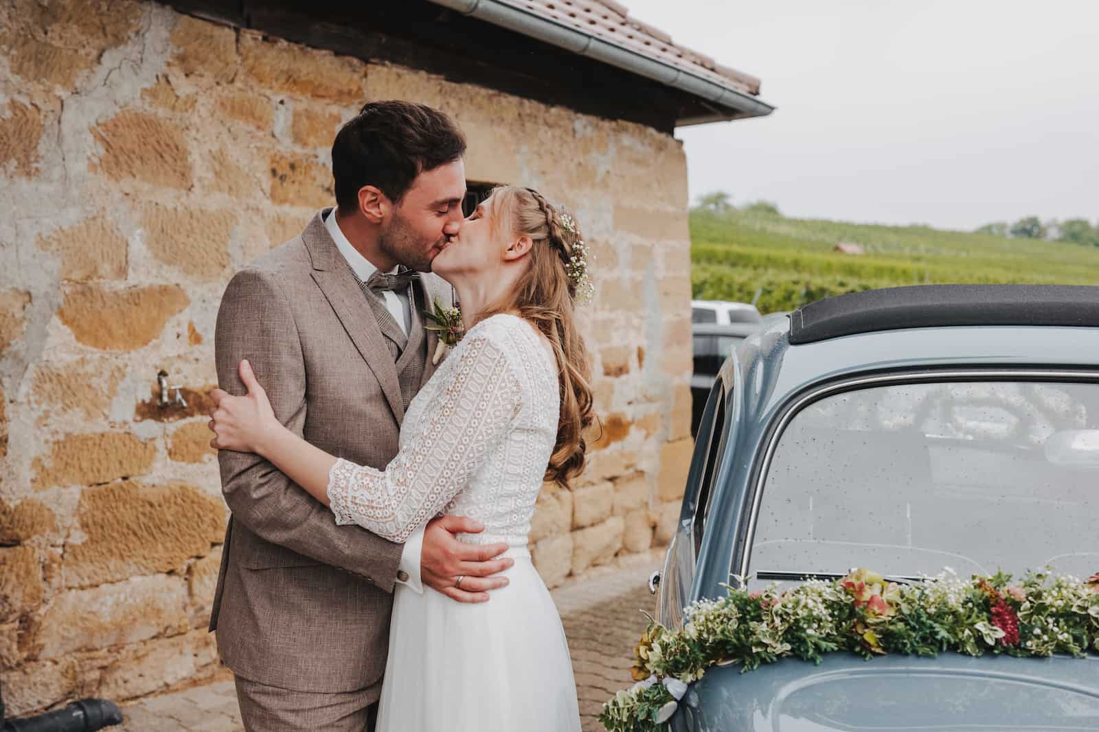 Hochzeitsfotografie in Langenbeutingen: Brautpaar küsst sich vor einem Oldtimer