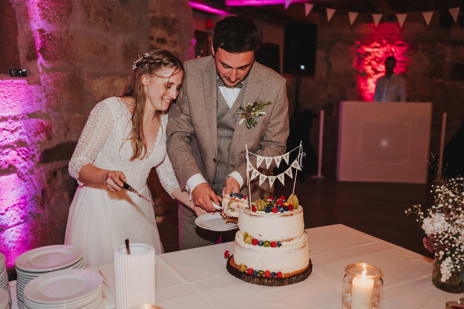 Hochzeitsreportage in Langenbeutingen: Brautpaar schneidet Hochzeitstorte an, fotografiert vom Hochzeitsfotografen Niklas Hesser.