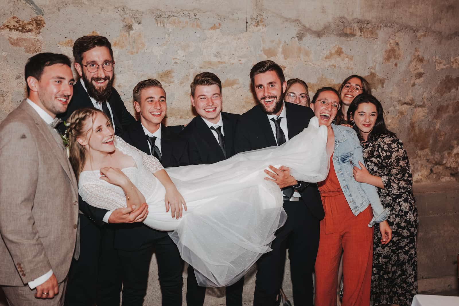 Hochzeitsgesellschaft hebt die Braut bei einer Hochzeitsreportage in Langenbeutingen hoch, fotografiert vom Hochzeitsfotografen Niklas Hesser.