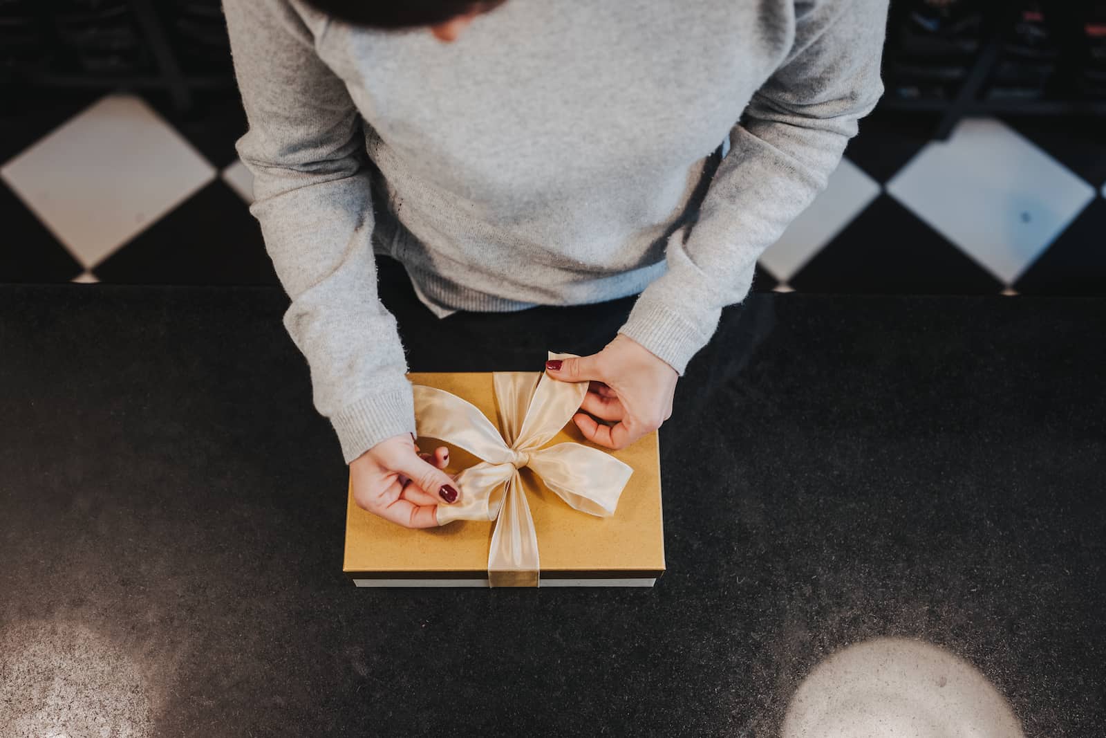 Unternehmensreportage in Heilbronn: Person verpackt Geschenk mit Schleife