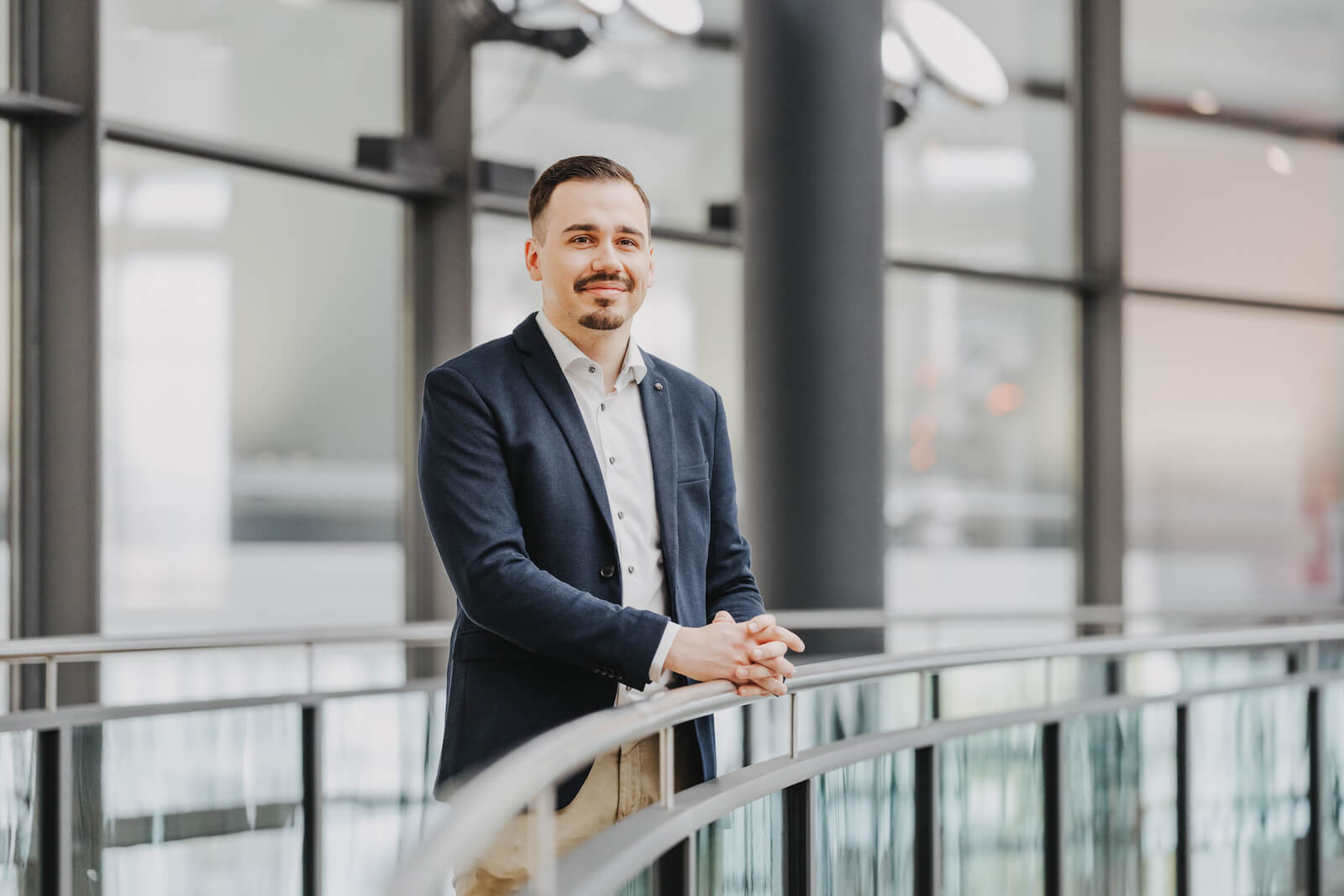 Businessportrait eines Mannes in einem modernen Bürogebäude in Neckarsulm, aufgenommen vom Fotografen Niklas Hesser.