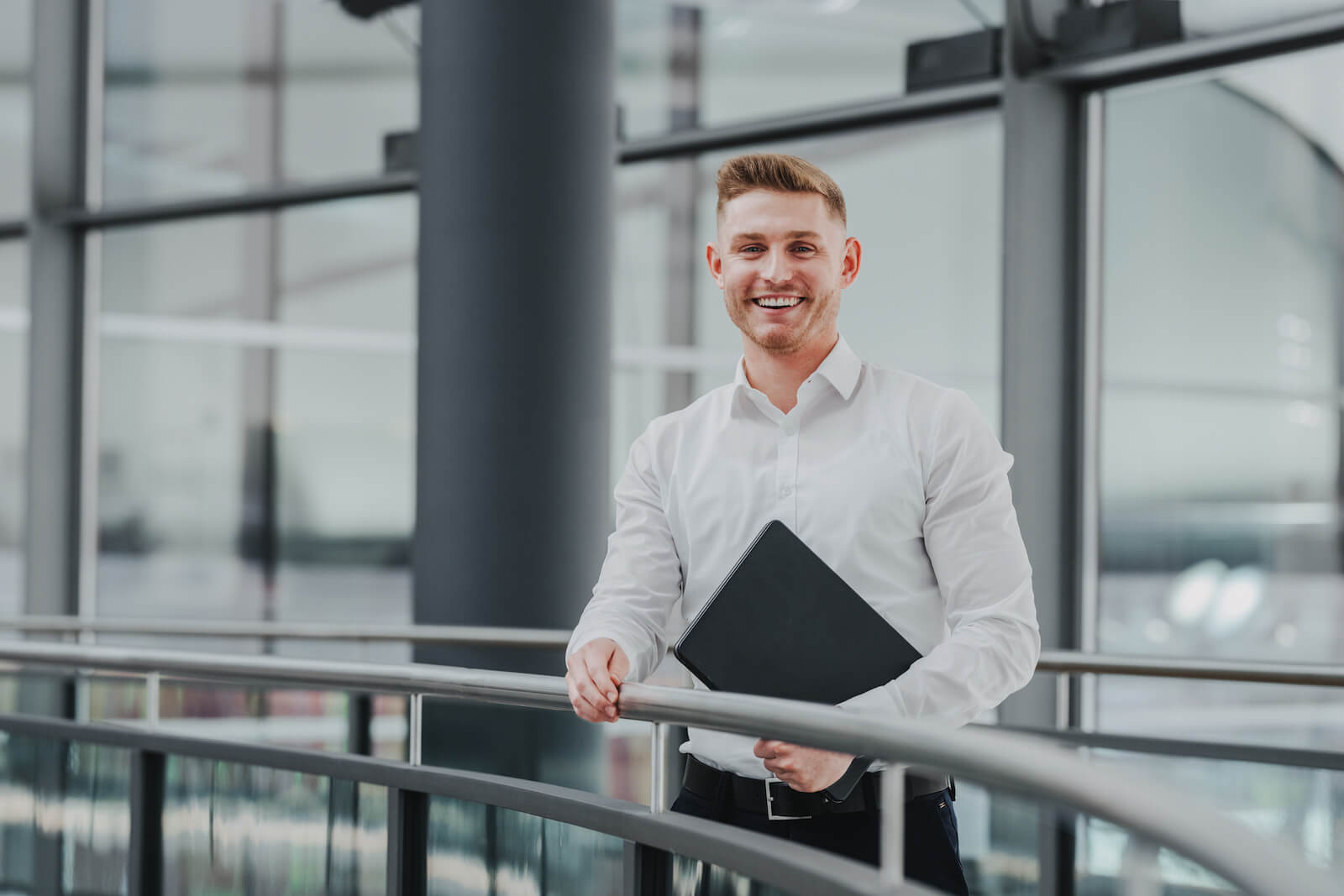 Businessporträt eines lächelnden Mannes in einem modernen Bürogebäude in Neckarsulm, aufgenommen vom Fotografen Niklas Hesser.