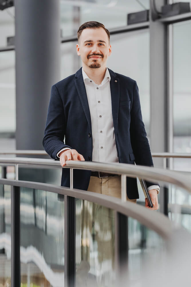 Businessporträt eines Mannes in einem modernen Bürogebäude in Neckarsulm, aufgenommen vom Fotografen Niklas Hesser.