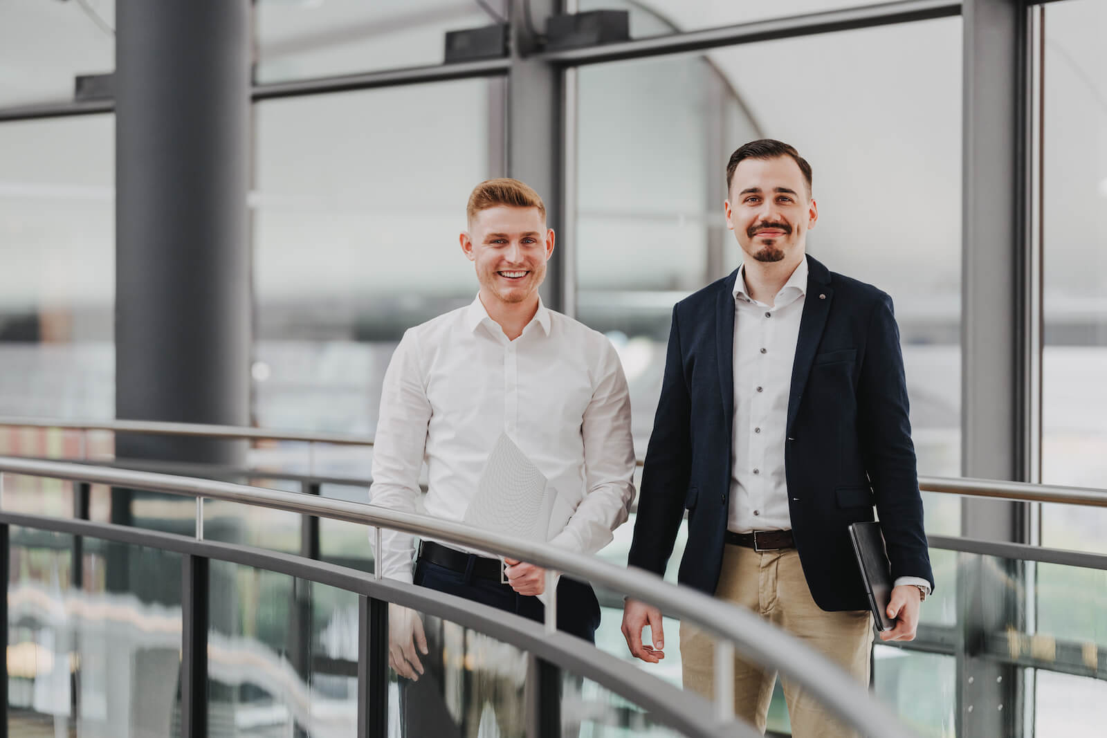 Businessportraits in Neckarsulm von zwei Männern in einem modernen Bürogebäude, aufgenommen vom Fotografen Niklas Hesser.
