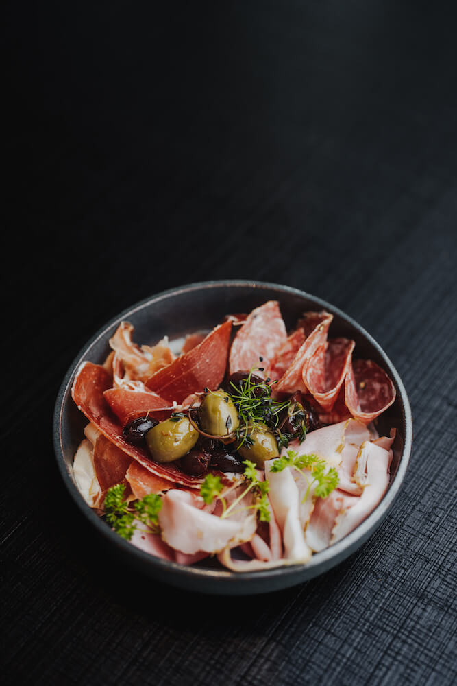 Food-Fotografie von einer Schale mit Antipasti auf dunklem Hintergrund, aufgenommen vom Fotografen Niklas Hesser in Heilbronn.
