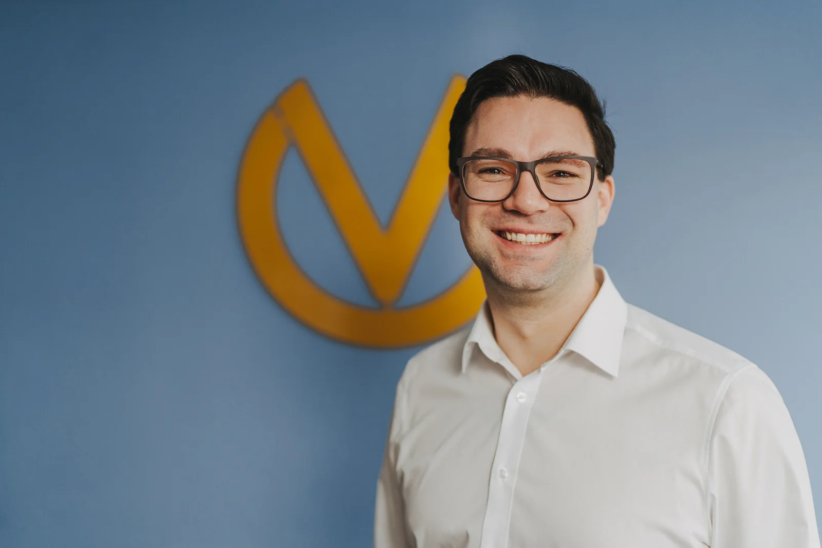 Businessportrait eines Mannes vor blauem Hintergrund in Heilbronn, fotografiert vom Eventfotografen Niklas Hesser.