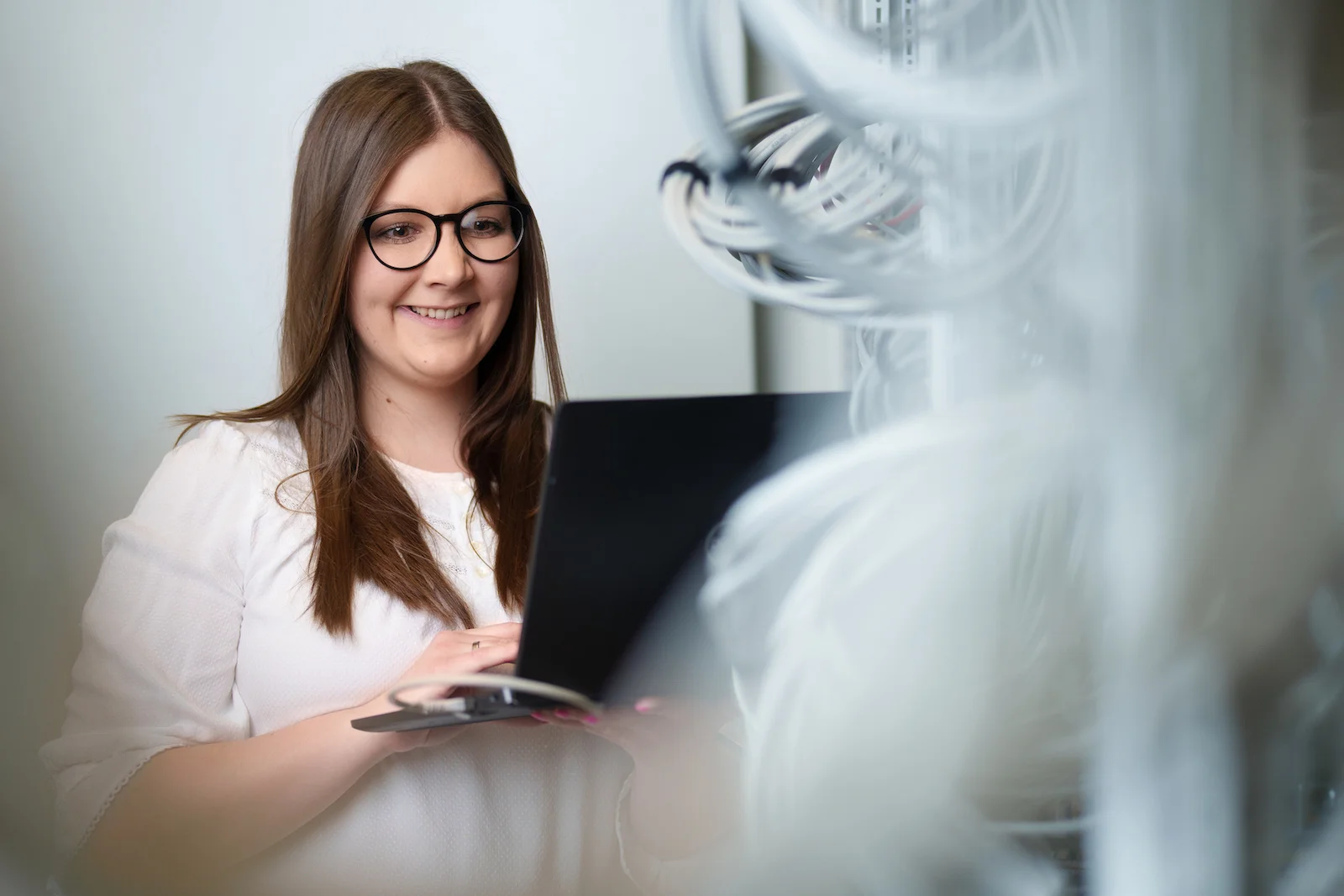Businessportrait einer Frau mit Laptop in einem modernen Büro, fotografiert vom Eventfotografen Niklas Hesser in Heilbronn.