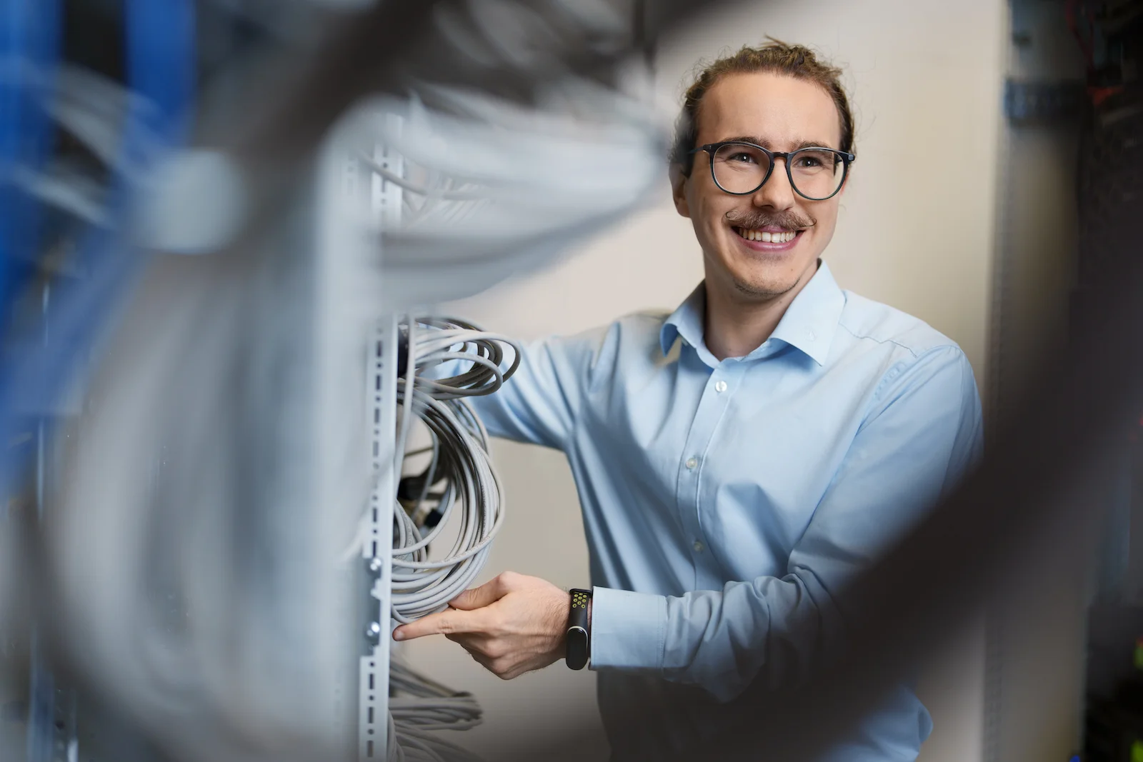 Businessporträt eines lächelnden Mannes in einem Serverraum, fotografiert vom Eventfotografen Niklas Hesser in Heilbronn.