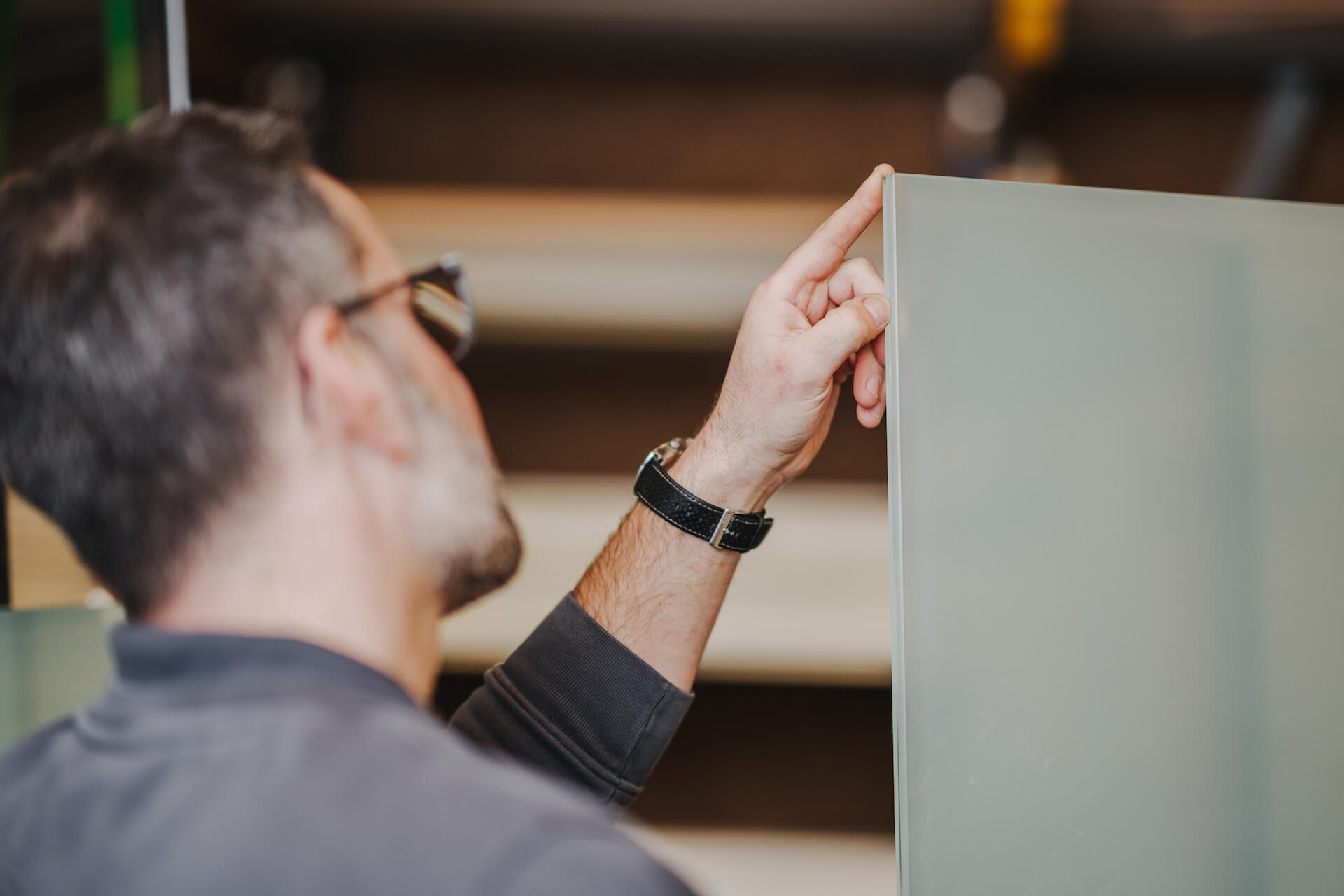 Businessfotografie in Neckarsulm: Detailaufnahme eines Mannes, der ein Glas überprüft.