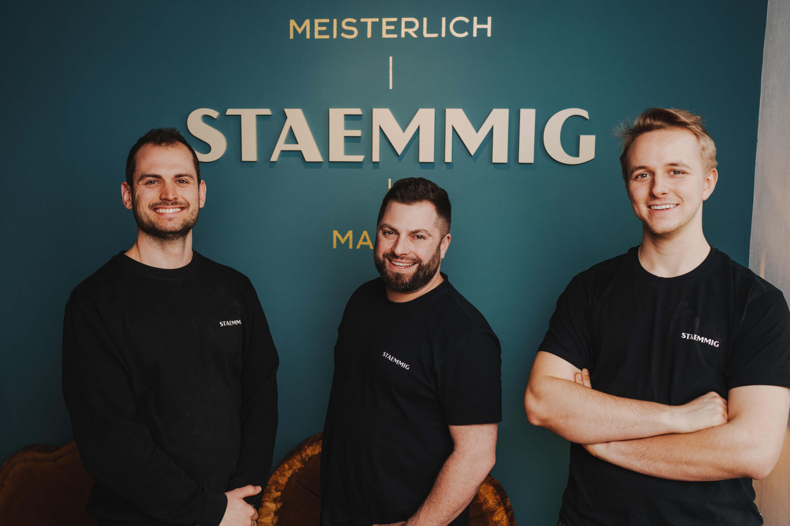 Businessporträt von drei Männern vor einem Firmenlogo in Obersulm, aufgenommen vom Eventfotografen Niklas Hesser.