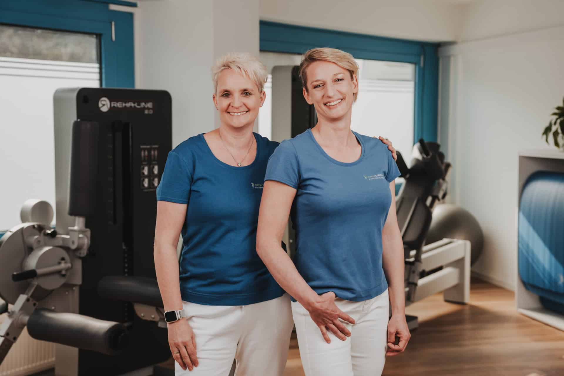 Die beiden Inhaberinnen Grötzinger und Schmückle von PhysioLogisch Erlenbach im herzlichen Duo-Portrait vor modernen Reha-Geräten