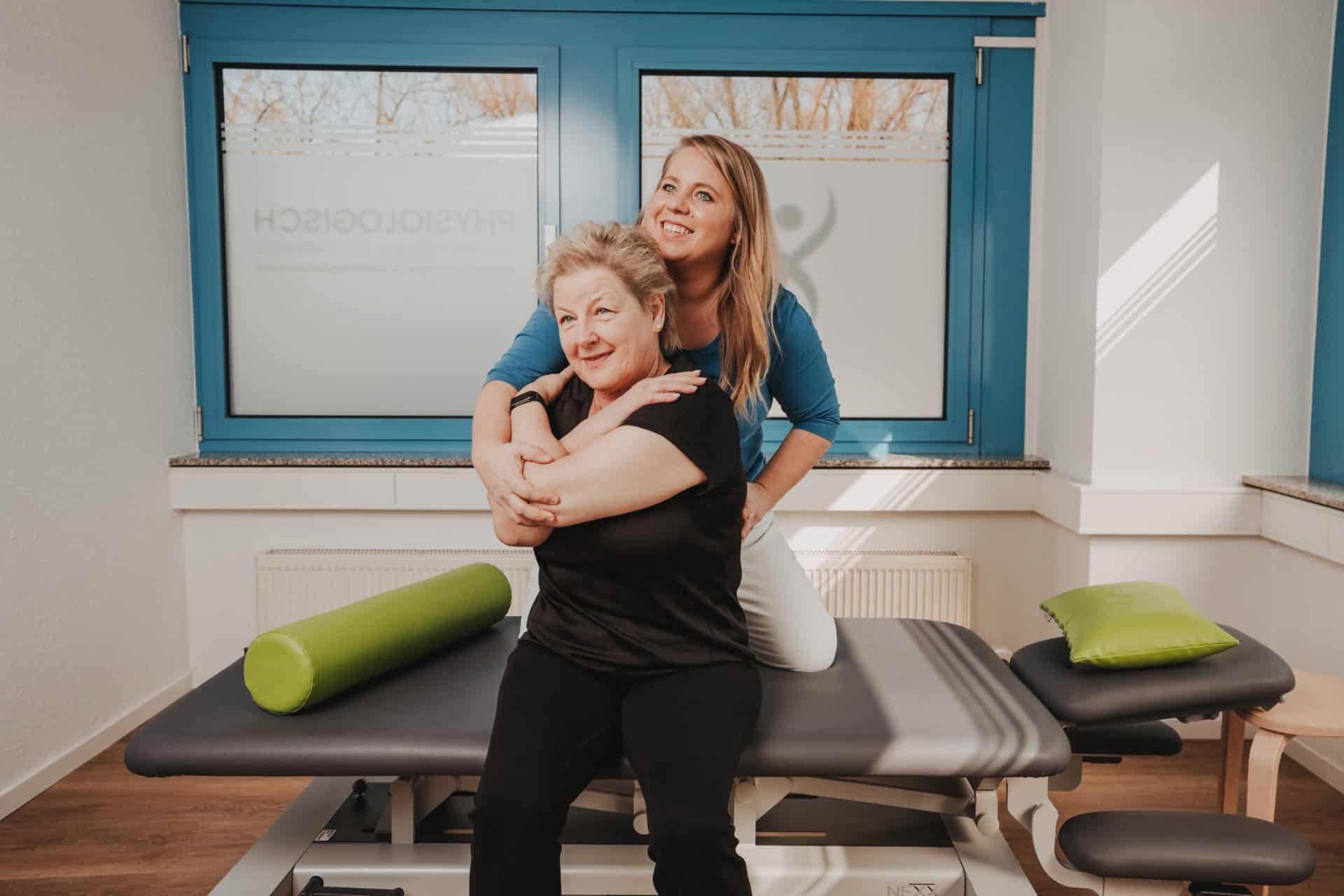 Physiotherapeutin von PhysioLogisch Erlenbach führt manuelle Mobilisation der Wirbelsäule an Patientin auf der Behandlungsliege durch